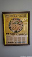 Framed vintage Labatt's Pilsener advertisement poster with yellow background and cartoon character Mr. Pilsener.