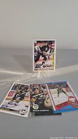 Four Mario Lemieux hockey cards arranged and one displayed on stand.