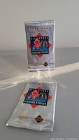 Two unopened Upper Deck McDonald's All Stars hockey card packs sealed in silver foil packaging with blue and red graphics.