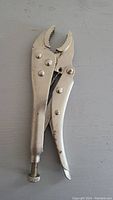Metal locking pliers (vice grip) showing the full tool from a side angle with jaws partially open