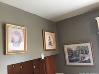 Overall view of three framed floral art pieces hung on wall