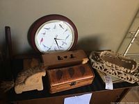 Photo shows two wooden boxes with lids, a carved wood basket, wooden horse with fiber mane and tail, and a round bird clock with wooden frame.