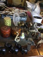 Wide view of the lot showing candles, brass and wooden animal figurines, ceramic bell, and large decorative glass plate.