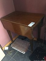 Front and top view of the vintage drop leaf table showing closed leaves, wood surface has visible scratches and wear spots.