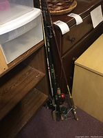 Full view of multiple fishing rods with reels leaning against furniture, showing rod lengths and handles