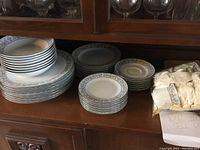 Full set grouped on a shelf showing stacks of plates, bowls and cups
