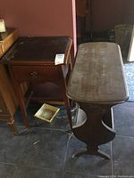 Side view showing the shape and design of the magazine rack with tapered legs and curved sides.