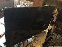 Front view of the TCL flat screen TV on stand.