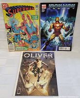 Photo showing all three comics with covers visible: Superman, Iron Man, and Oliver