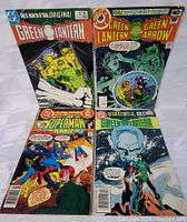 All four comic books arranged together on a white surface showing front covers