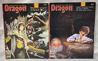 Photo shows front covers of two Dragon magazines, issues #85 and #88, displayed side by side showing detailed cover art and titles.