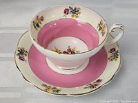 Foley tea cup and saucer set showing pink interior and floral decoration with gold trim