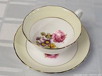 Tea cup and saucer set showing floral design inside the cup and on the saucer, gold rim detail