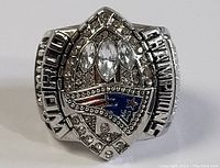 Close-up front view of the replica football championship ring showing the rhinestone detailing and Patriots logo.