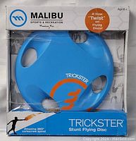Front view of packaged Malibu Trickster stunt flying disc, showing brand and product info on box