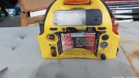 Front view of the yellow 6 in 1 jump starter system showing control panel and outlets.