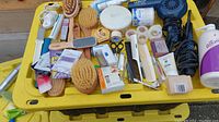 Overview of assorted bathroom supplies and grooming tools on a yellow container
