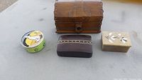 Four trinket boxes displayed on a flat surface, showing variety in design and material.