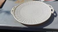 View of the oval serving platter showing textured ribbed pattern and one ornate handle.