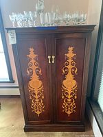 Front view showing cabinet doors, inlay design, handles and overall condition