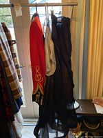 Black sheer dress or costume piece hanging next to jacket
