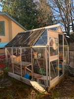 Front-right exterior view of greenhouse showing overall structure, frame and glass panels.