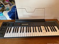 Front view of Roland Juno-1 synthesizer keyboard with music stand attached