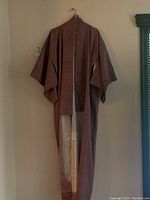 Full view of the kimono hung on a hanger showing overall shape, color, and sleeve style.