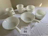 Photo showing all items including 4 fruit bowls, 2 mugs, and 2 soup bowls with handles in white opaque glass.