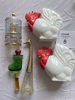Six Avon collectible cologne bottles in different shapes including roosters, giraffe, boot, and ornate bottle with gold top.