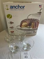 Photo showing the Anchor branded box for 2-piece dome and base dessert set, with four clear dessert dishes arranged in front.