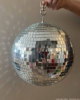 Disco ball held showing full front and mirrored surface