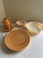 Full set displaying 4 cups stacked on saucers, 2 dessert bowls, one casserole dish, and 4 dinner plates.