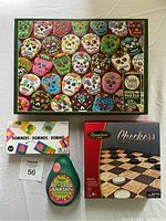 Photo showing all four items in the lot: Cobble Hill Sugar Skull Cookie puzzle box, Signature Games Checkers set box, Montoy Dominoes box, and Ridleys Avocado Smash card game avocado-shaped container.