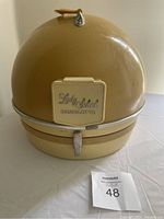 Front view of the vintage beige Lady Schick Consolette hair dryer showing the dome hood with the Lady Schick Consolette logo on a front panel and a metal latch on base.