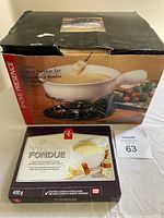 Photo of the original box showing the Home Presence 10-piece cheese fondue set with pot and stand.