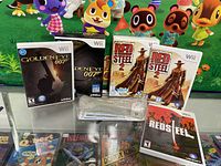 Photo showing GoldenEye 007 and Red Steel 2 boxed editions for Nintendo Wii along with clear plastic accessory case and game cases with manuals