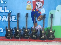 All six Guitar Hero Live guitar controllers lined up, showing front view with buttons and necks visible