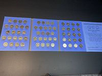 Rows of silver-coloured Canadian nickels mounted on blue coin storage pages showing multiple years of coinage from 1940 to 2022, arranged in orderly fashion.