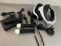 All components laid out on flat surface showing headset, controllers, cables, and processor unit.