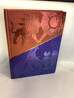 Front cover of the hardcover Pokemon Sun & Moon Collector's Edition strategy guide showing embossed Solgaleo and Lunala with red and blue background.