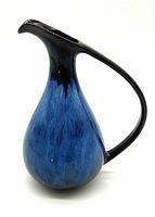 Front and side view of the blue drip glaze ceramic pitcher with elongated handle and spout, showcasing mid century style.