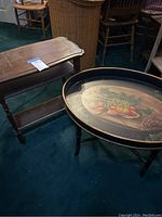 Photo showing dark wood book shelf end table with curved top and bottom shelf on blue carpet floor.