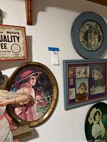 Wall display showing four art pieces including Coca-Cola themed Gibson Girl oval frame and Roth's Quality Coffee sign.