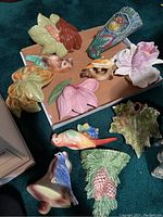 Multiple ceramic wall pocket vases arranged on box, various shapes and glazes visible