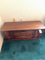 Overall front view of the wooden midcentury Lane cedar chest showing the two handles and wood grain.