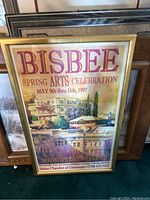 Framed poster for Bisbee Spring Arts Celebration in 1997 showing event details and an artistic image of buildings with a gold frame.
