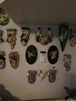 Overview of all ceramic bird wall vases and plaques mounted on wall
