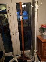 Photo showing all three coat racks positioned together: two white racks and one natural wood finish rack.