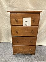 Front view of the antique 4 drawer wooden nightstand showing all drawers and structure.
